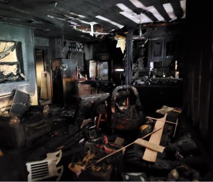 Living room completely charred black after a fire.